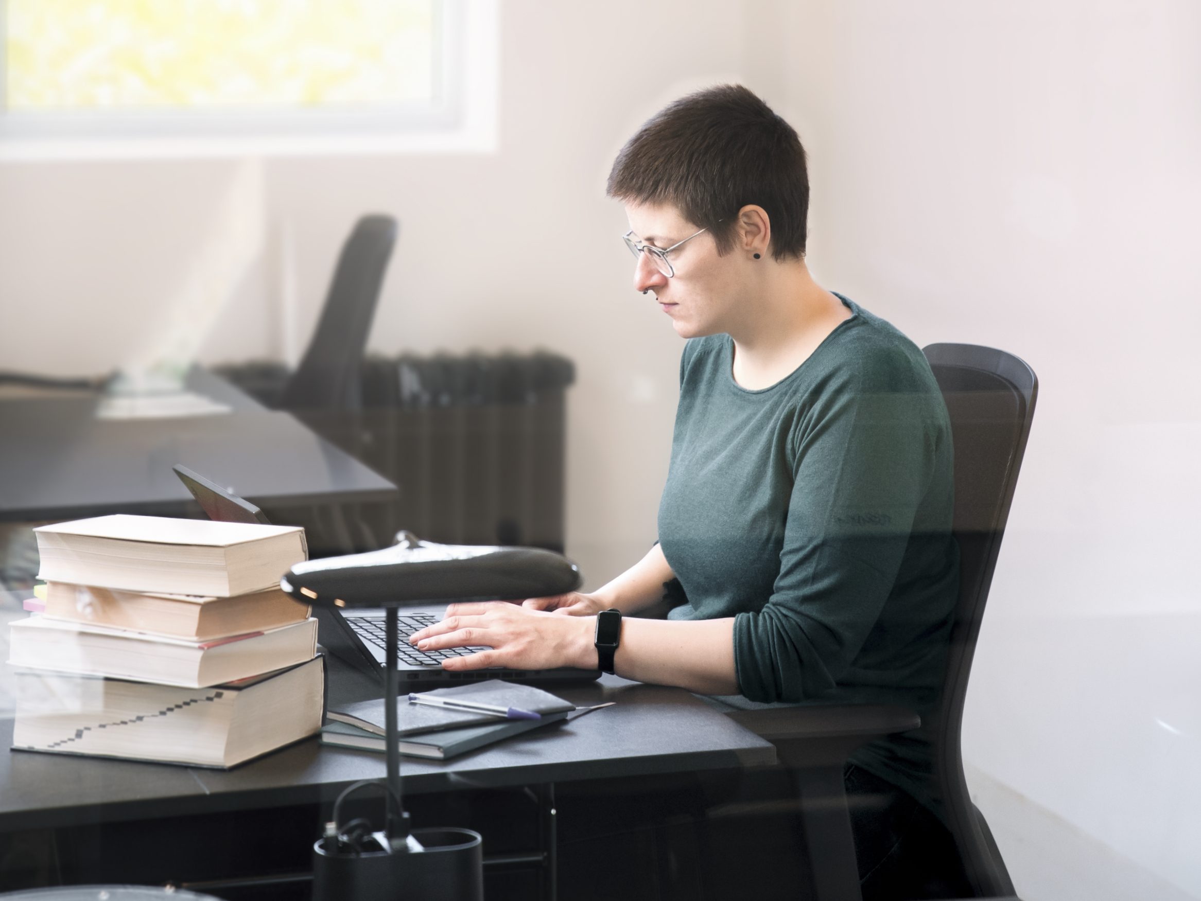 Franziska Maria Schade sitz an einem Schreibtisch und schreibt einen Artikel über Content Marketing für ihren Blog.